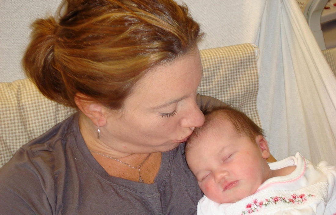 Mother kissing newborn